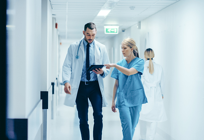 Female Surgeon and Doctor walking through hospital hallway